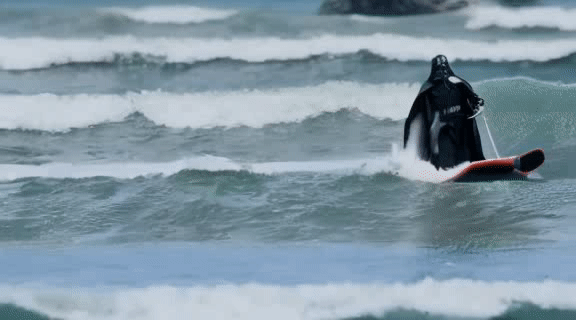 Darth vader surfing in waves.