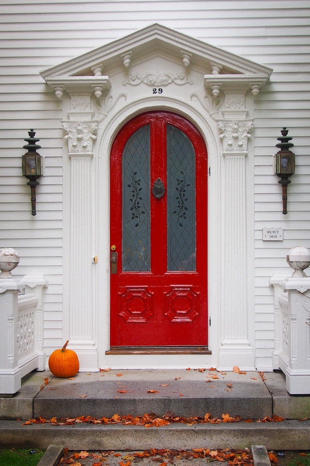 Image of a red door with a pumpkin on the steps