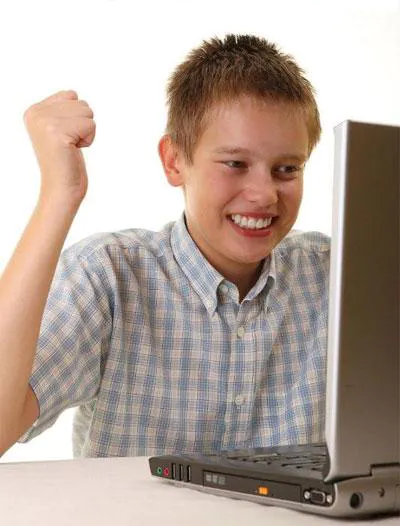 a young boy is smiling while using a laptop .png
