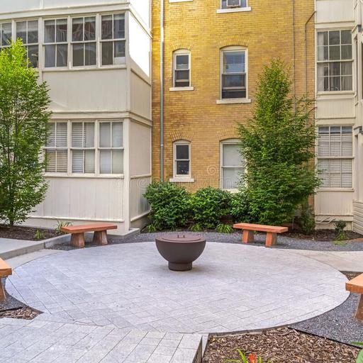 04361362---square-stone-benches-around-fire-pit-outside-residential-building-sunny-day-pathways-plants-can-also-be-seen-homes-171086572.jpg