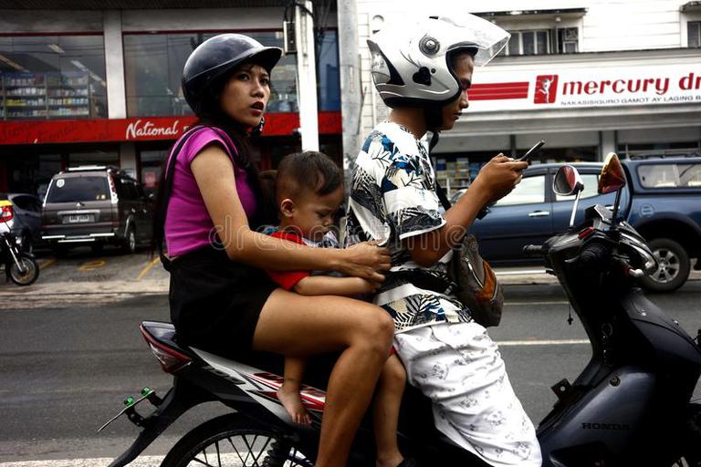 03991425---filipino-couple-their-children-ride-motorcycle-wait-green-light-intersection-major-road-antipolo-city-158460924.jpg